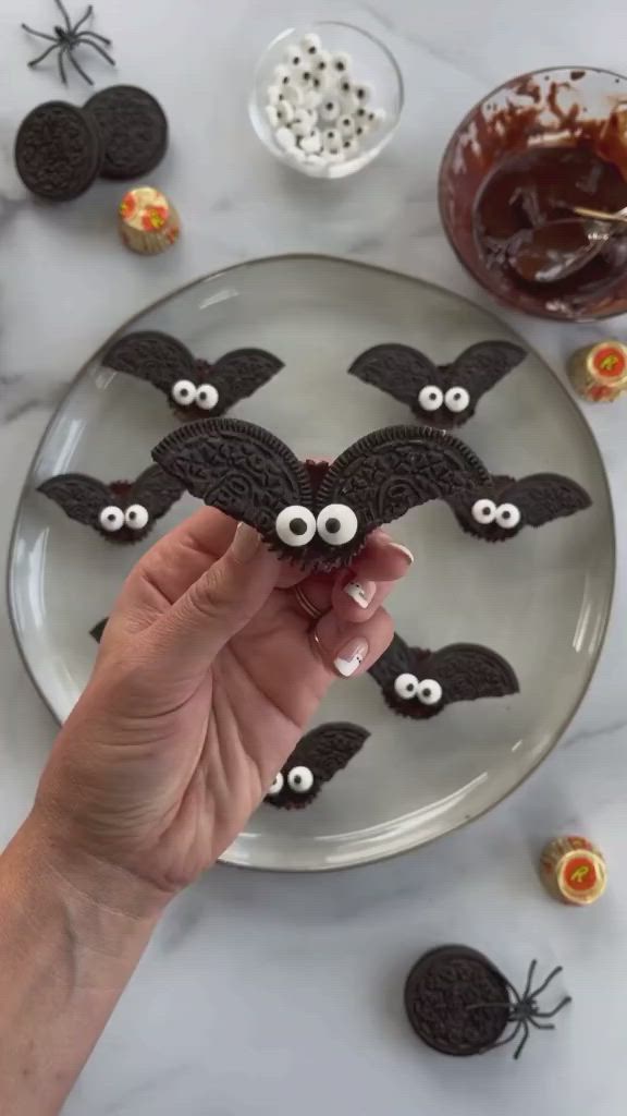 This may contain: a plate with cookies decorated to look like bats and eyes, sitting on a table