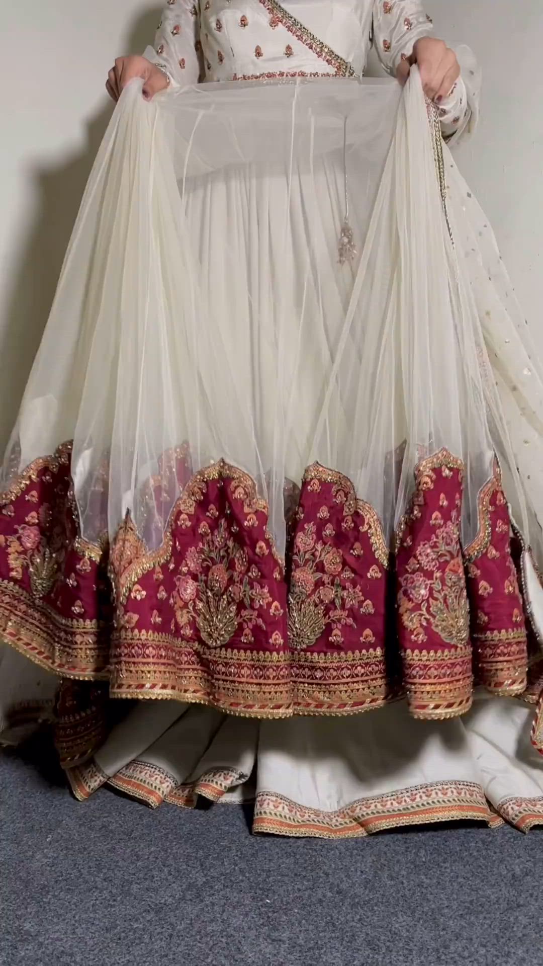 beautiful white frock with red embroidery on it.