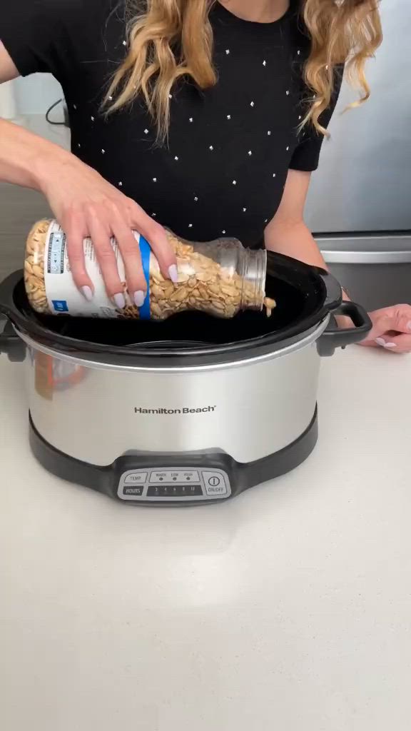 This may contain: a woman is pouring something into a crock pot