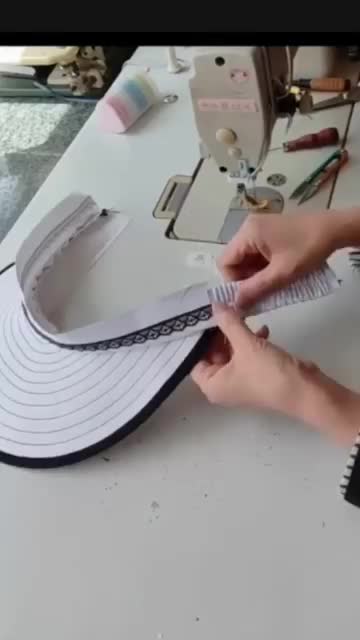 This may contain: a woman is working on a hat at a sewing machine with scissors and measuring tape