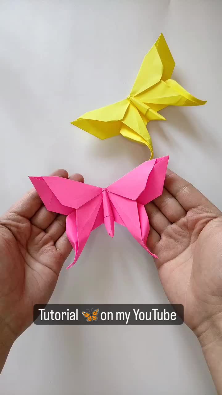 This may contain: two hands holding origami birds in front of each other