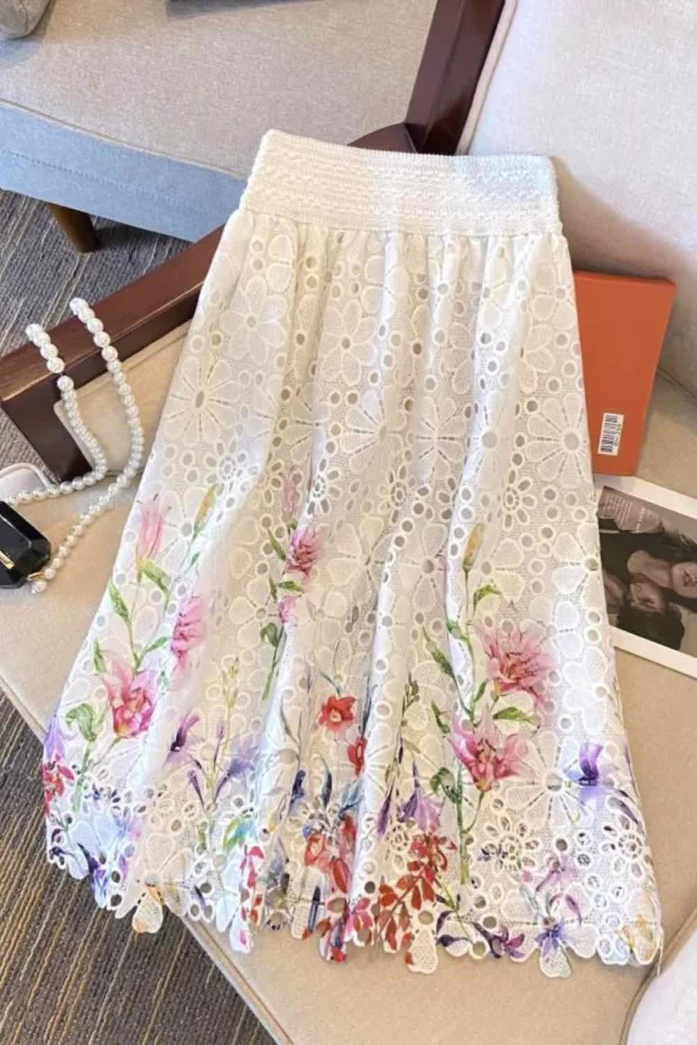 Elevate your spring and summer look with this elegant high-waist skirt featuring a delicate floral print and intricate lace embroidery. Its loose silhouette exudes effortless charm and is perfect for warm-weather days. Ideal for those who appreciate refined style with a touch of romantic flair.