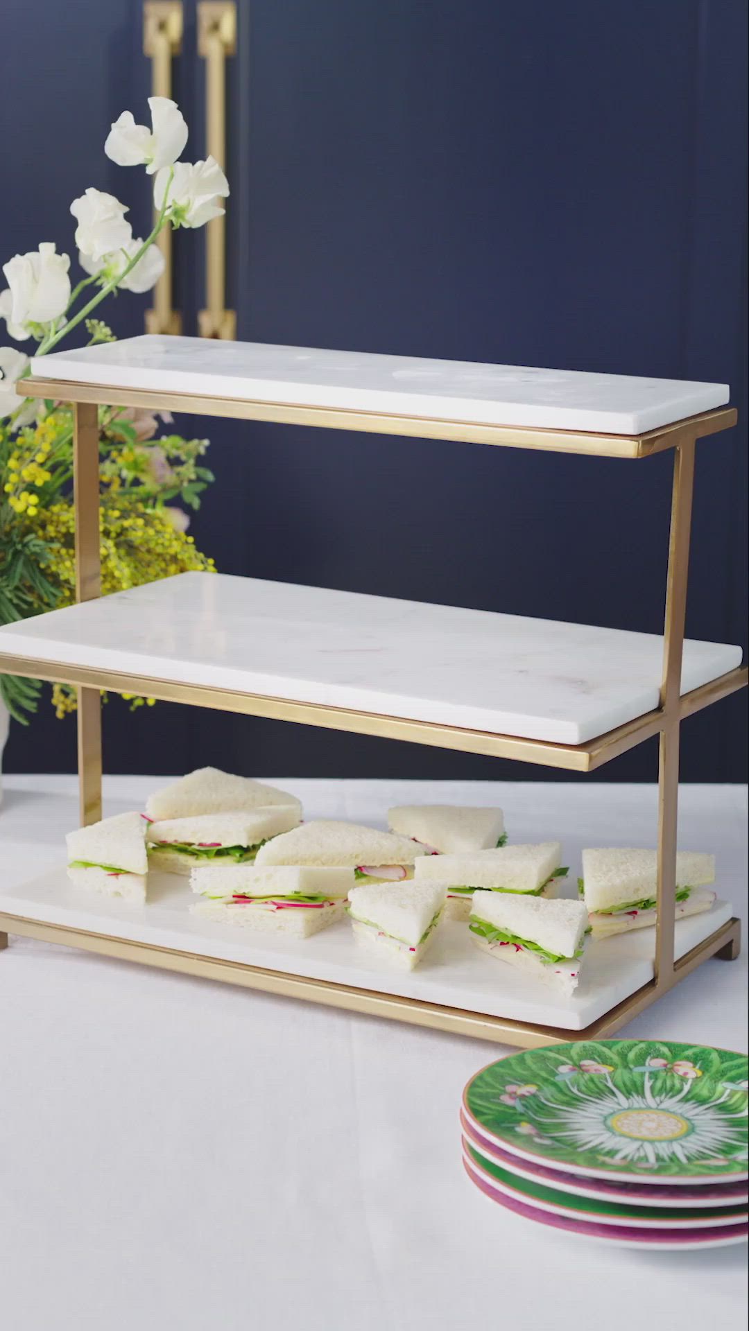 This may contain: two trays filled with sandwiches and pastries on top of a table