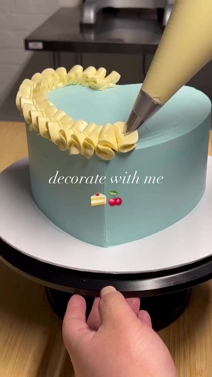 This may contain: someone is decorating a cake with yellow icing