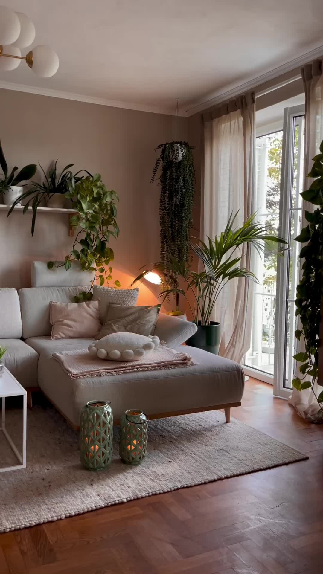 This may contain: a living room filled with furniture and lots of plants