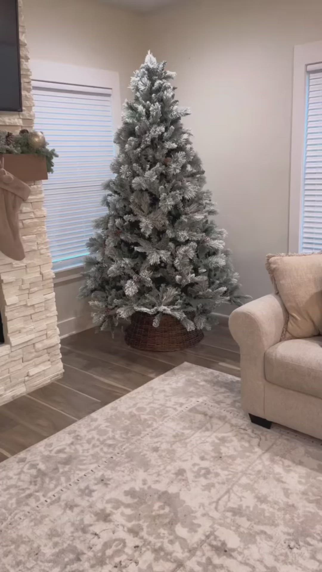 This may contain: a person holding up a gold heart shaped object in front of a christmas tree