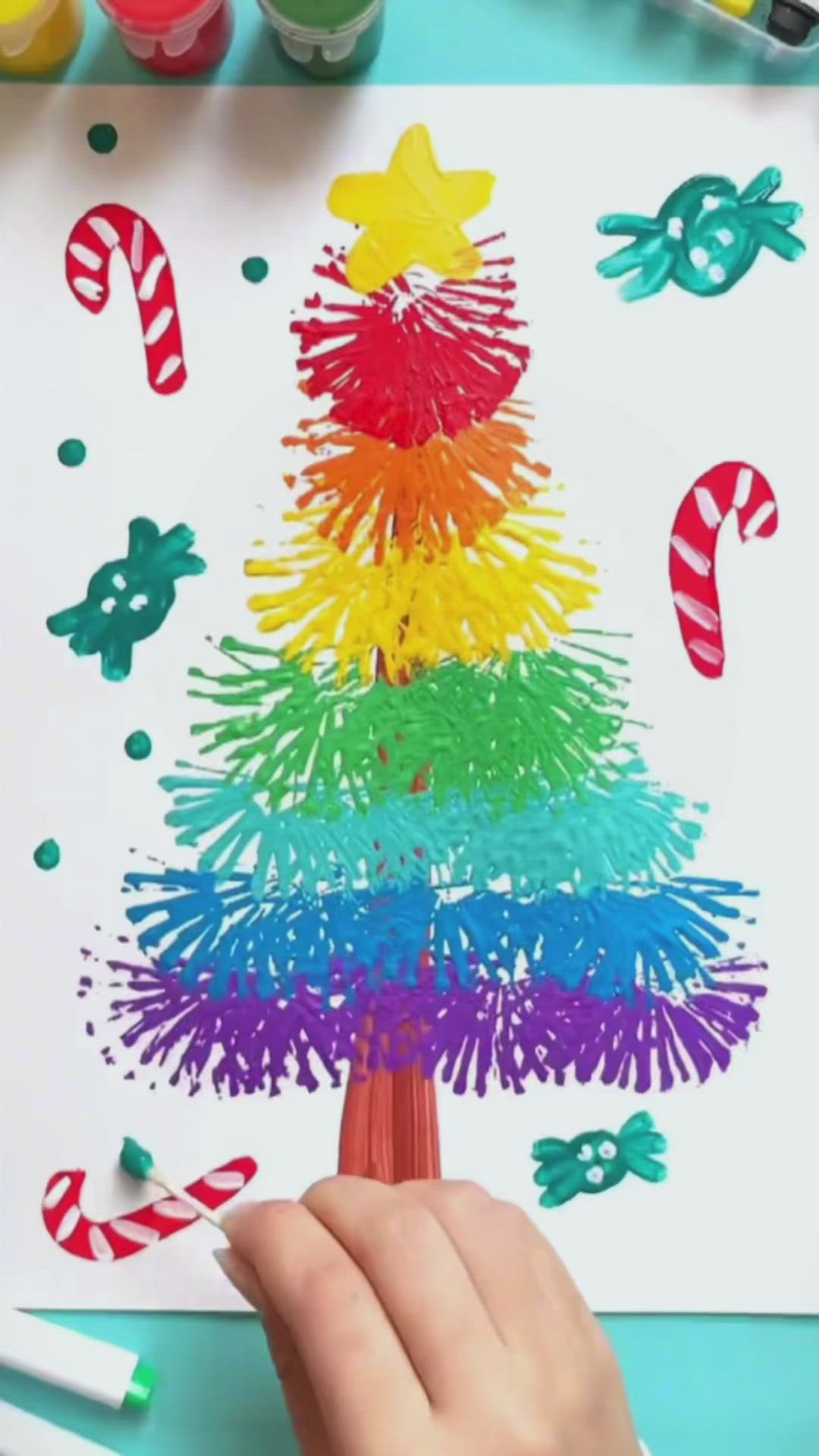 This may contain: someone is making a christmas tree out of crayons and colored paper with candy canes