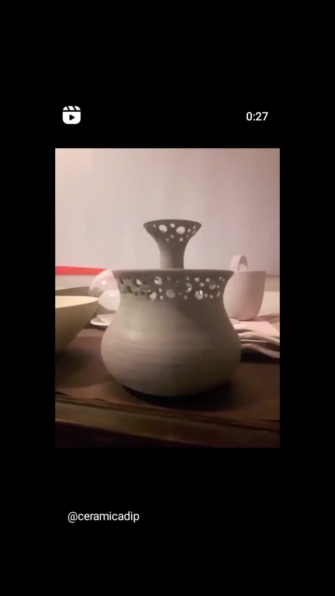 This may contain: a white vase sitting on top of a wooden table