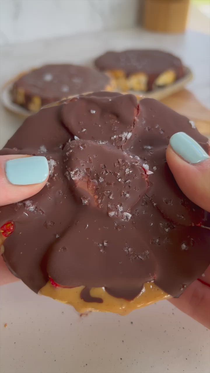 This may contain: a person holding up a chocolate covered doughnut with strawberries on it and the words, the best healthy snack