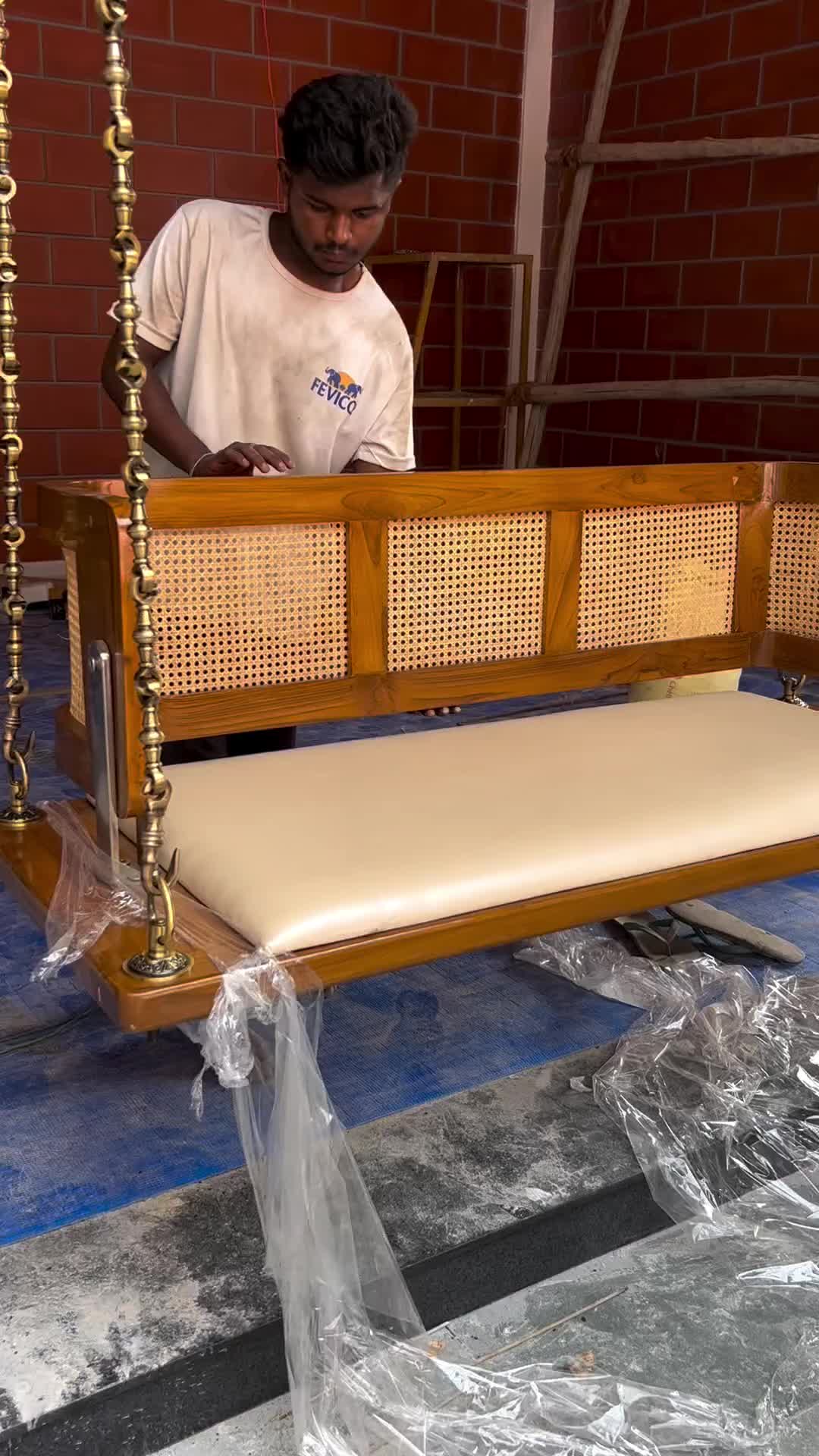 This may contain: two men working on a wooden bench in the process of being installed to a brick wall