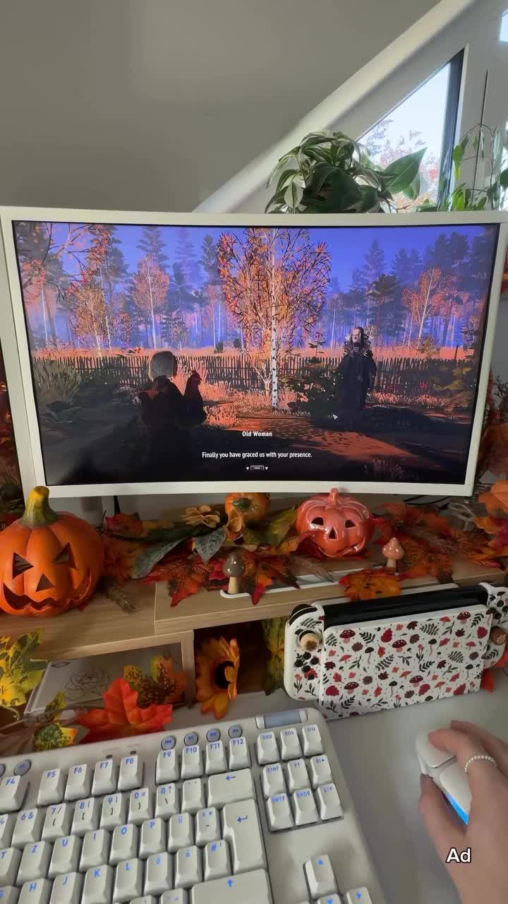 This may contain: a desktop computer sitting on top of a desk covered in fall leaves and pumpkins