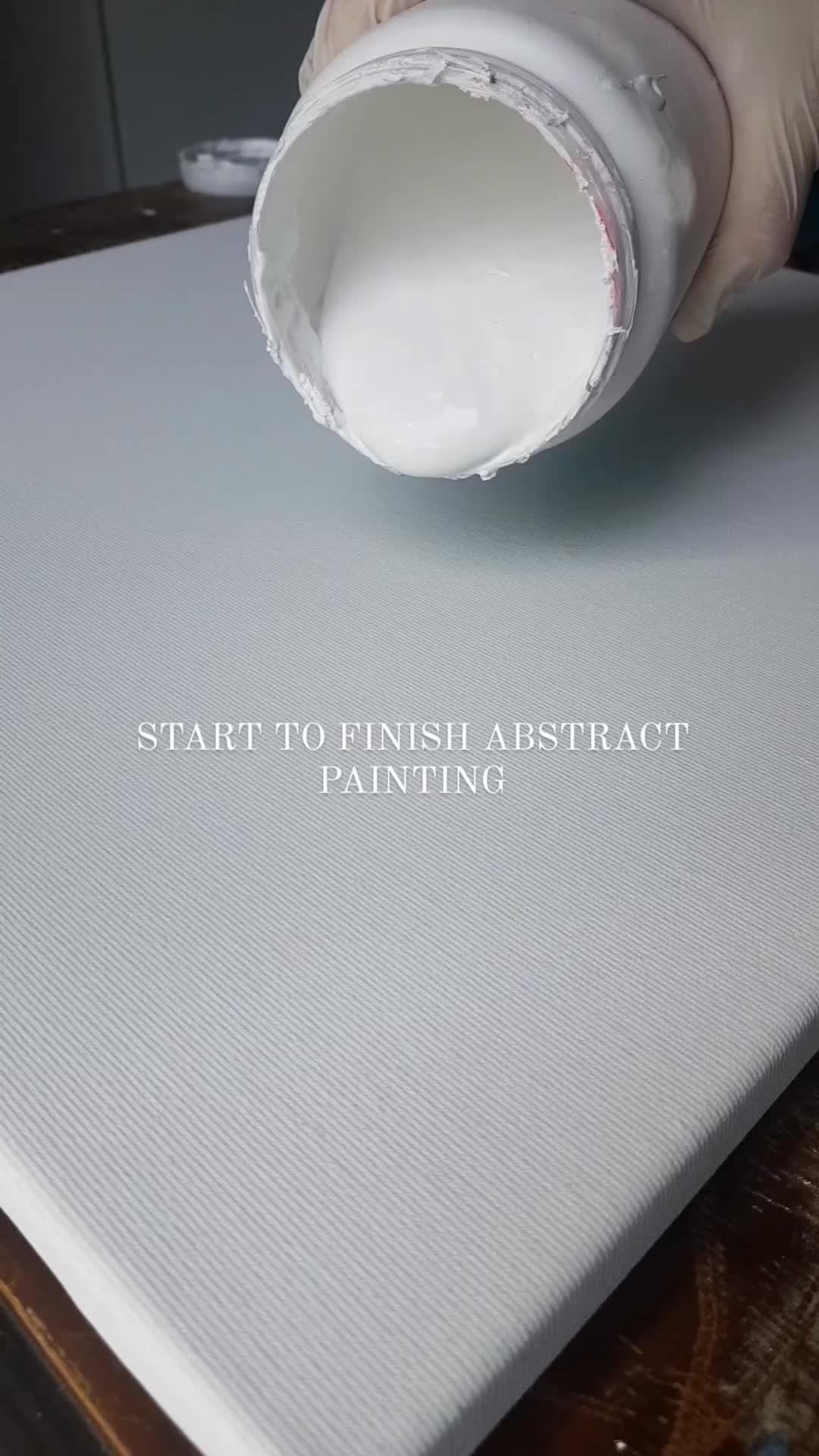 This may contain: a person in white gloves is pouring paint onto a piece of paper with the words start to finish abstract painting