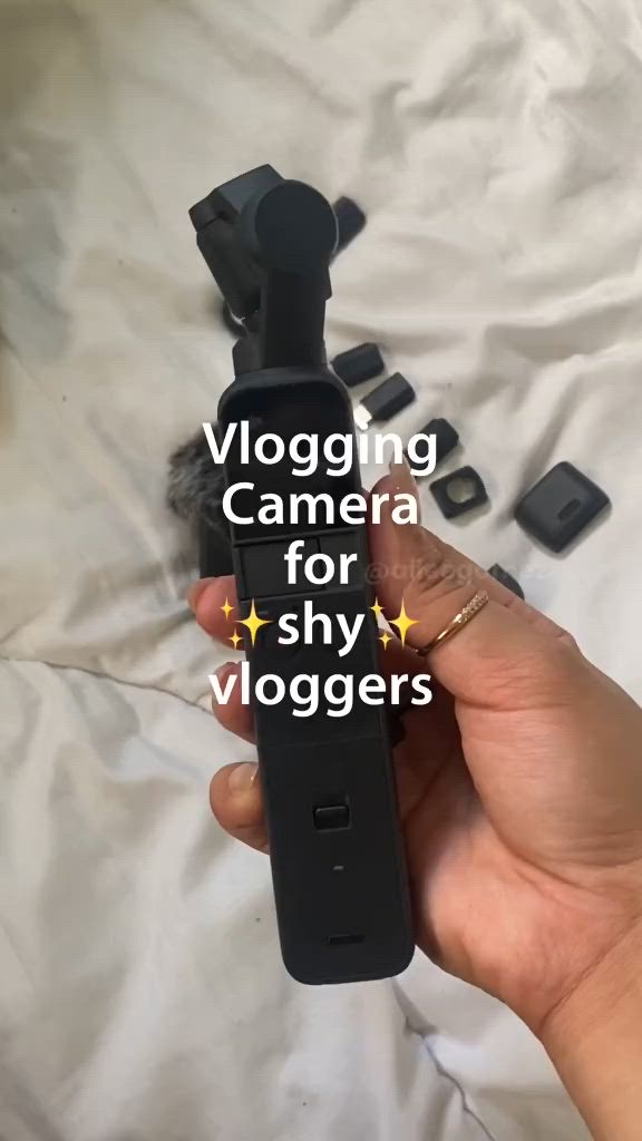 This may contain: a person holding a camera in their hand with the words vlogging camera for shy viggers