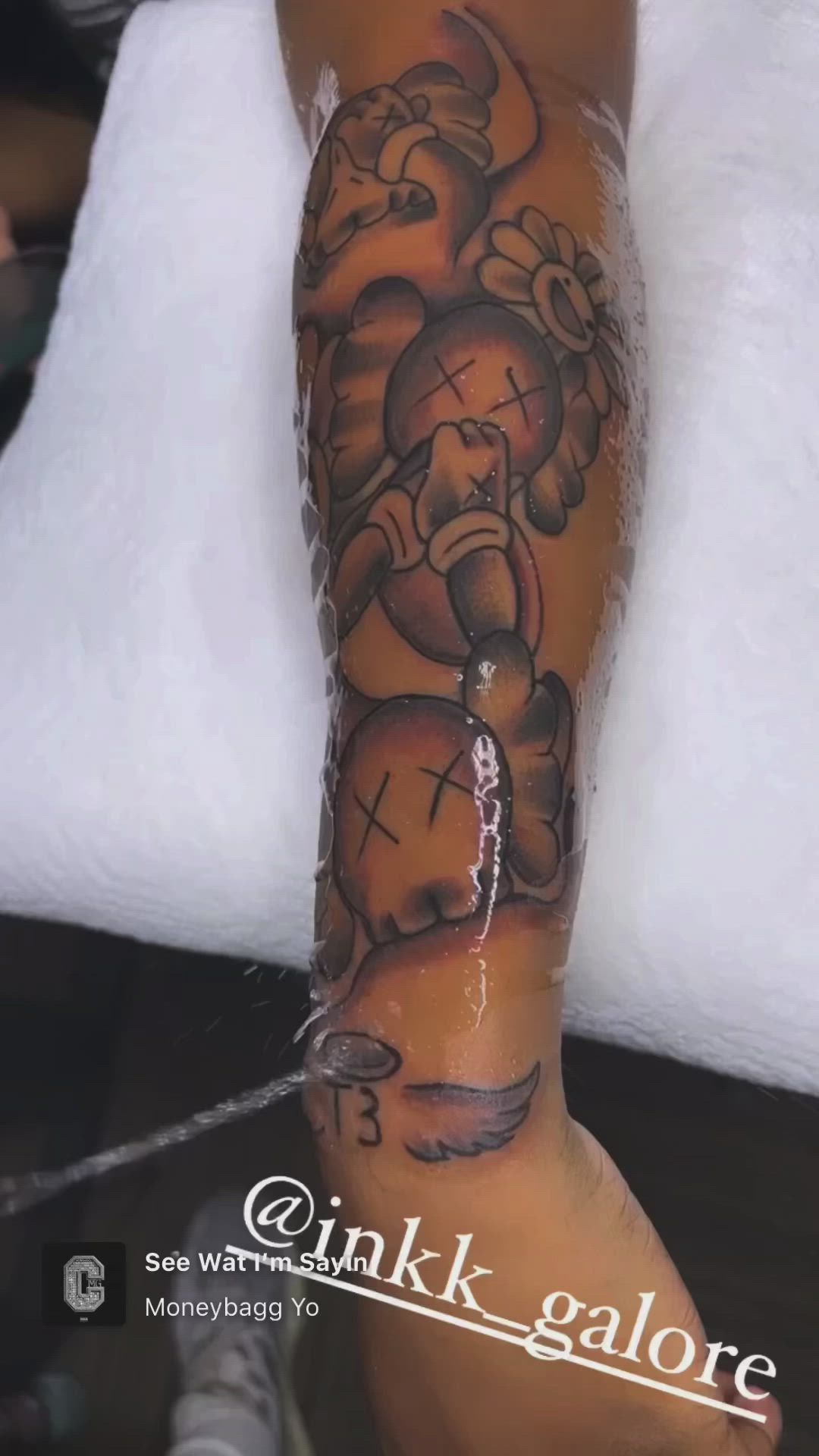 This may contain: a person with a tattoo on their arm and leg that has an elephant holding a cross