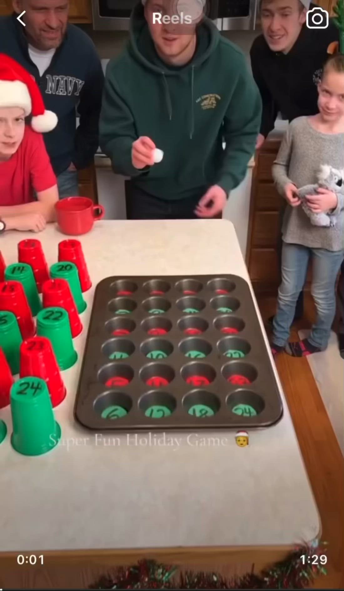 This may contain: a group of people standing around a table with cupcakes and christmas decorations on it