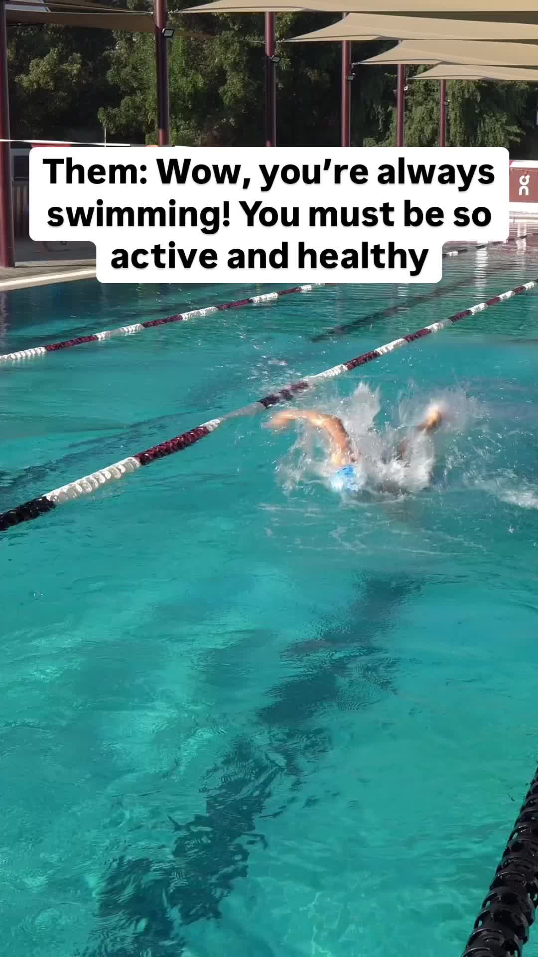 This may contain: a person swimming in a pool with an umbrella over it that says, them wow, you're always swimming you must be so active and healthy