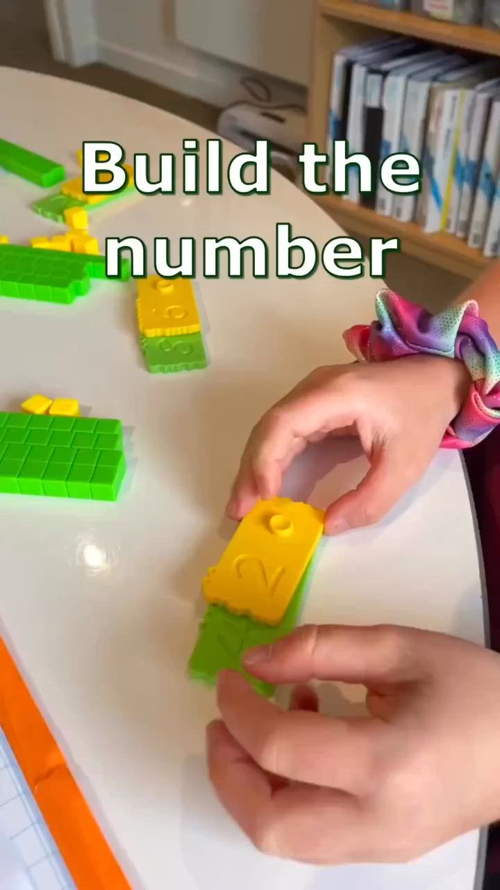 This may contain: a child is playing with legos on the table and building them into small blocks