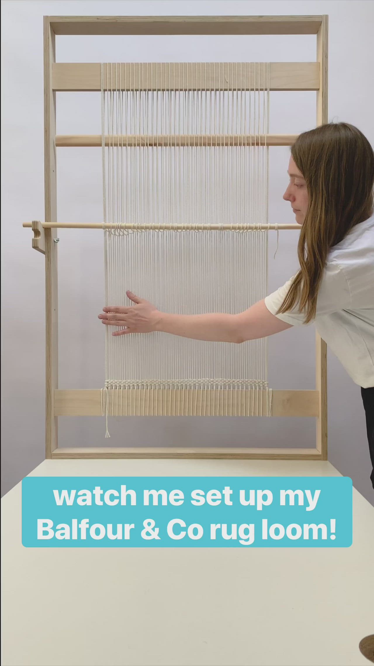 This may contain: a woman is trying to make a hand loom