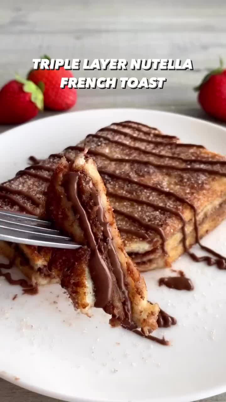 This may contain: a white plate topped with french toast covered in chocolate