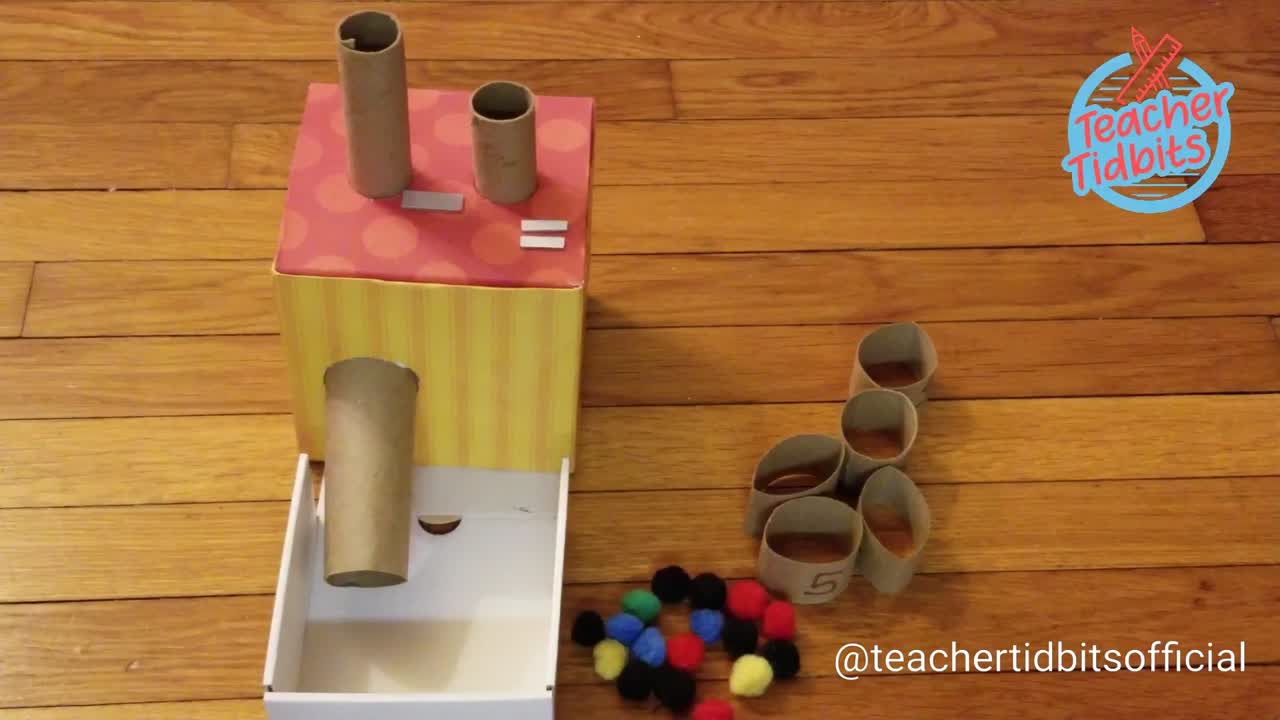 This may contain: someone is making a craft with toilet paper rolls and colored pom - poms