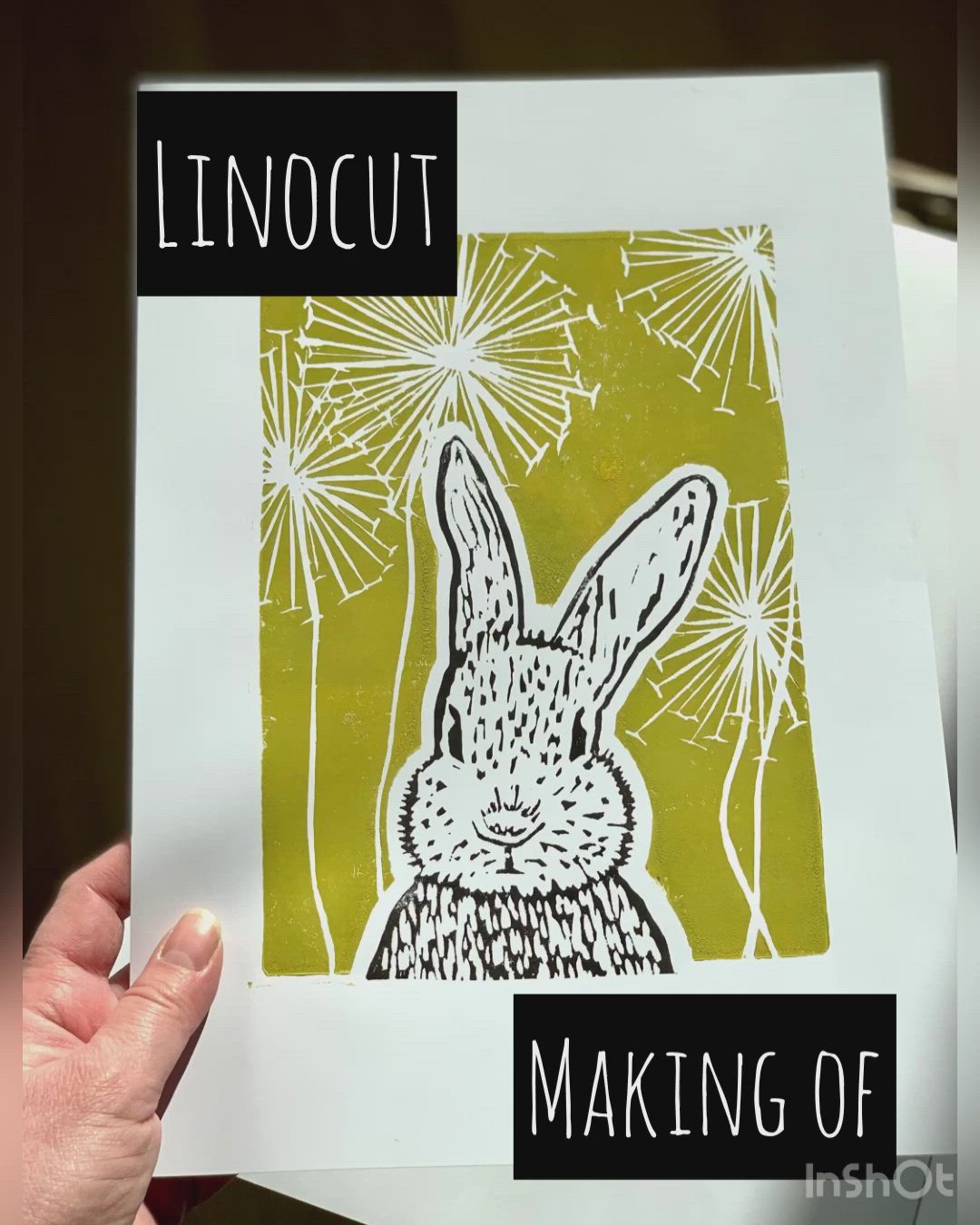 This may contain: a hand holding up a piece of paper with an image of a rabbit