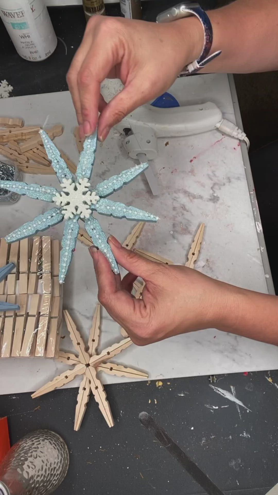 This may contain: two hands are making a snowflake out of popsicle sticks