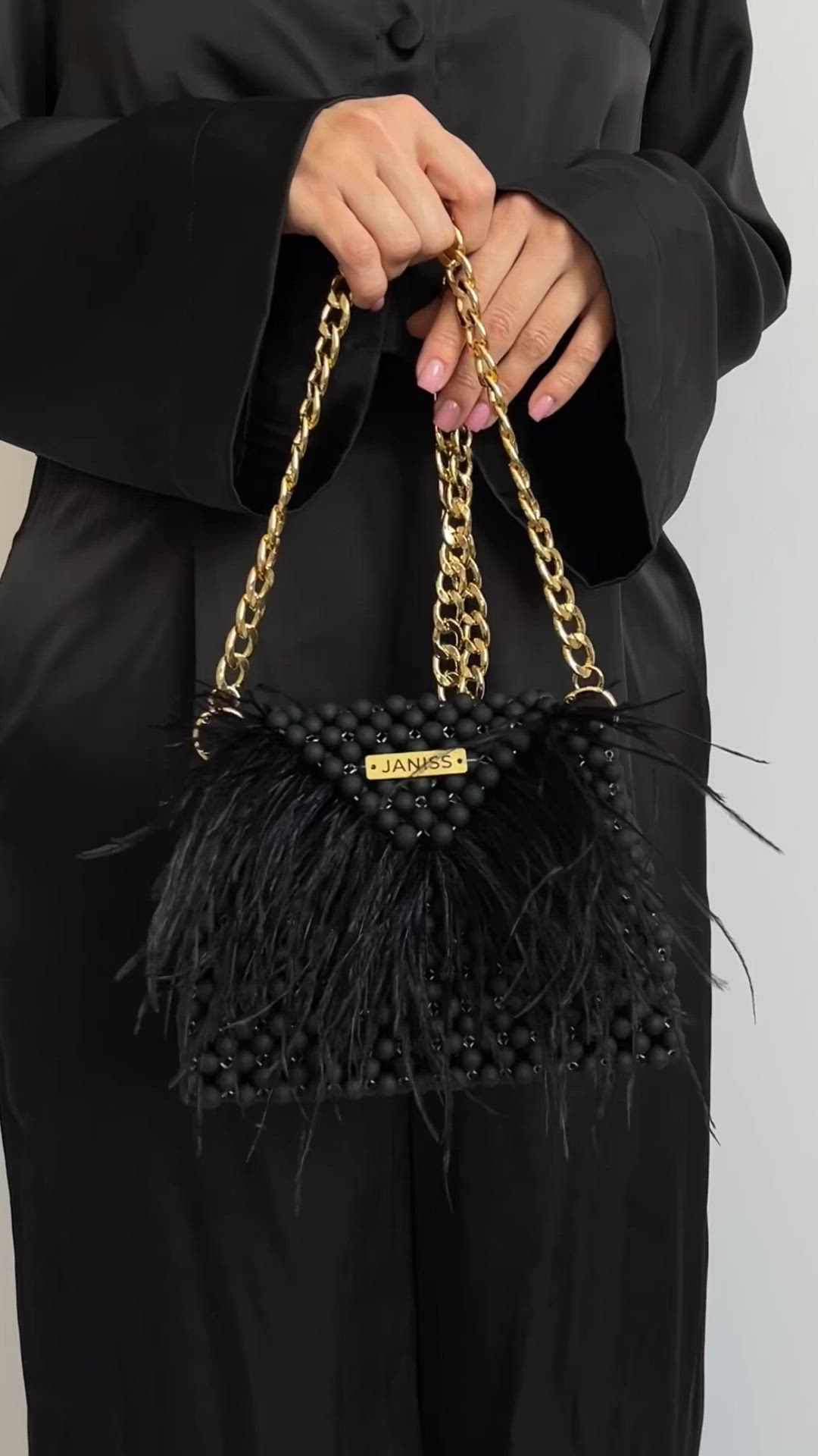 This contains an image of: matte black bag decorated with ostrich feathers