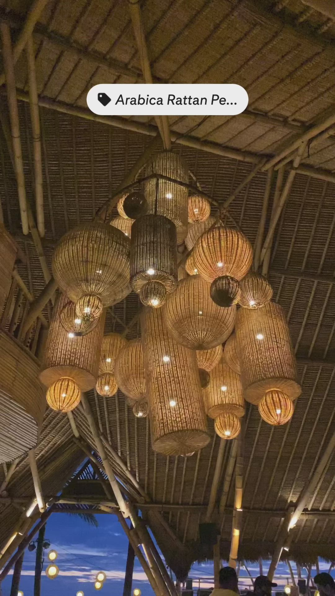 This may contain: the interior of an outdoor restaurant with hanging lights and wicker baskets on the ceiling