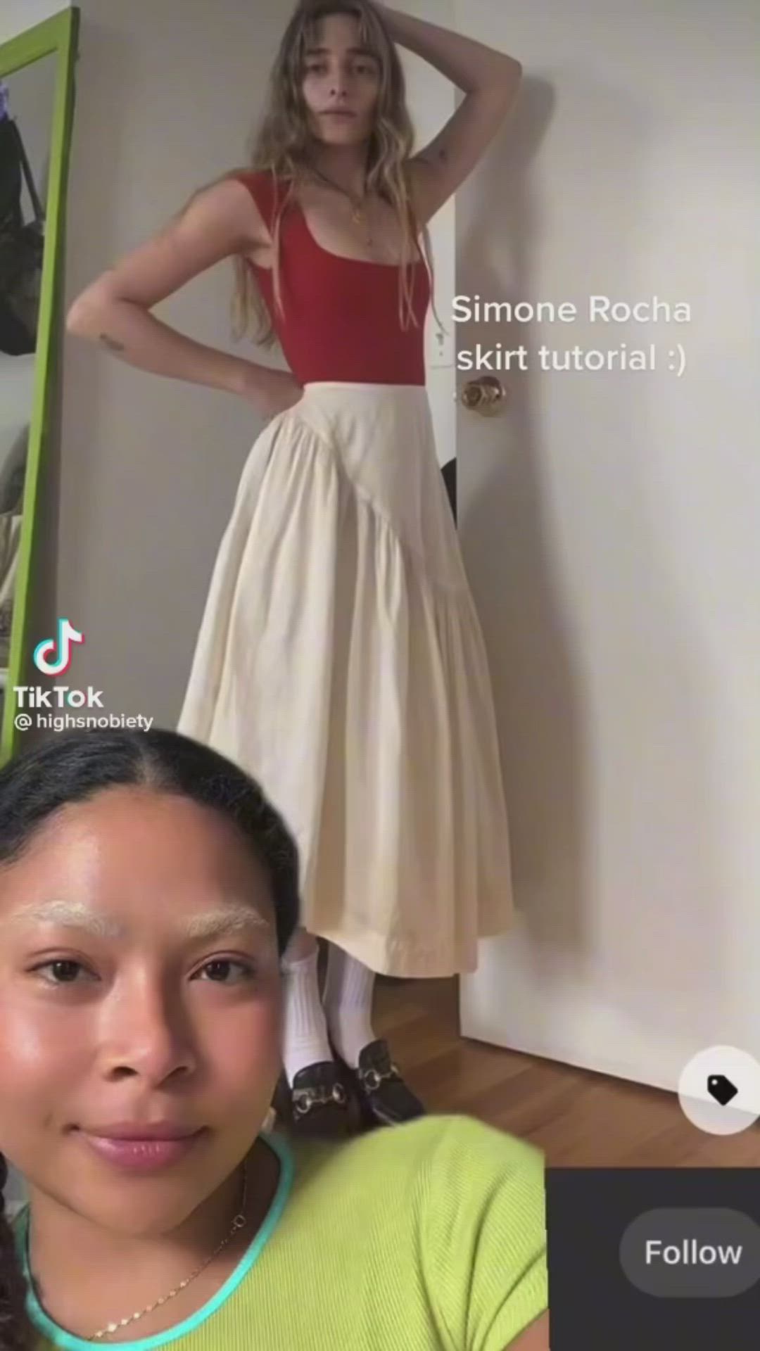 This may contain: a woman is standing in front of a mannequin wearing a red top and white skirt