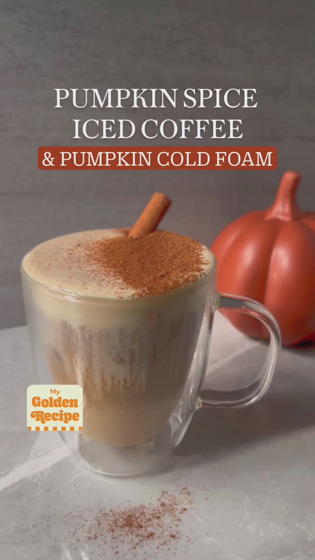 This may contain: pumpkin spice iced coffee and pumpkin cold foam in a glass mug with cinnamon on top