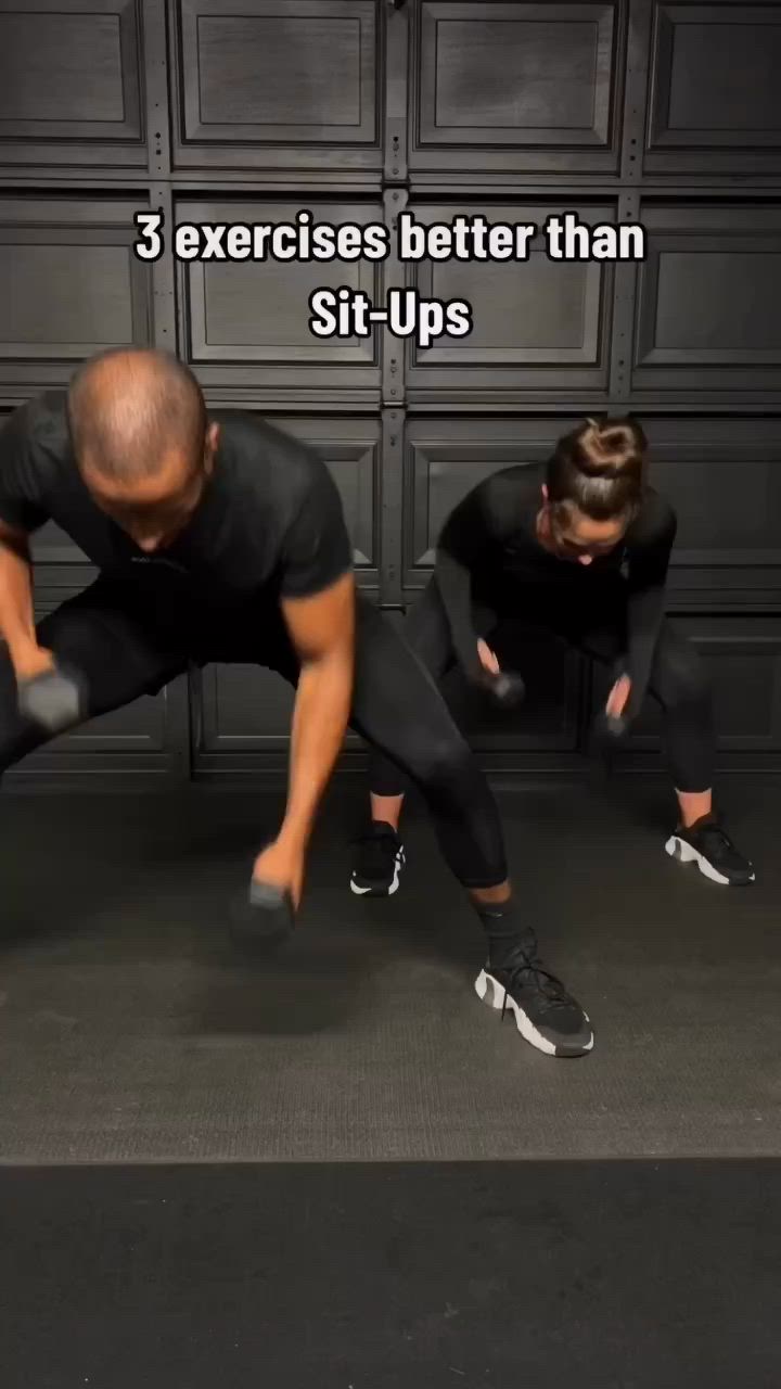 This may contain: two people are doing exercises with dumbbells in the dark, while one man is holding his arms up