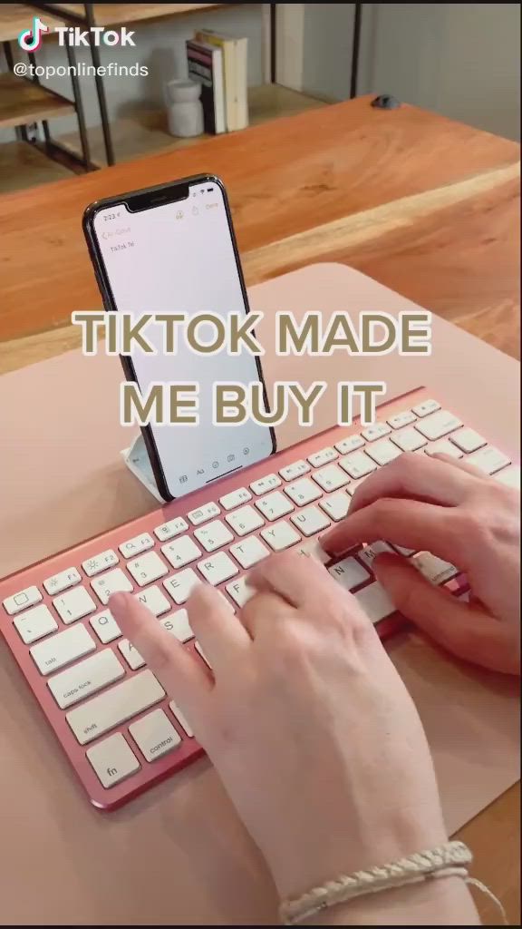 This may contain: a person typing on a keyboard with the caption tiktok made me buy it