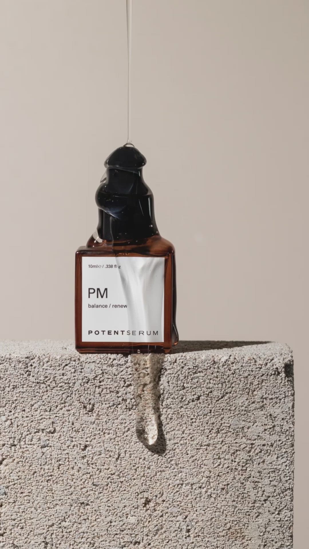 This may contain: a bottle of cologne sitting on top of a cement wall next to a sign that says, product photography using stone, water and hand sanitizer