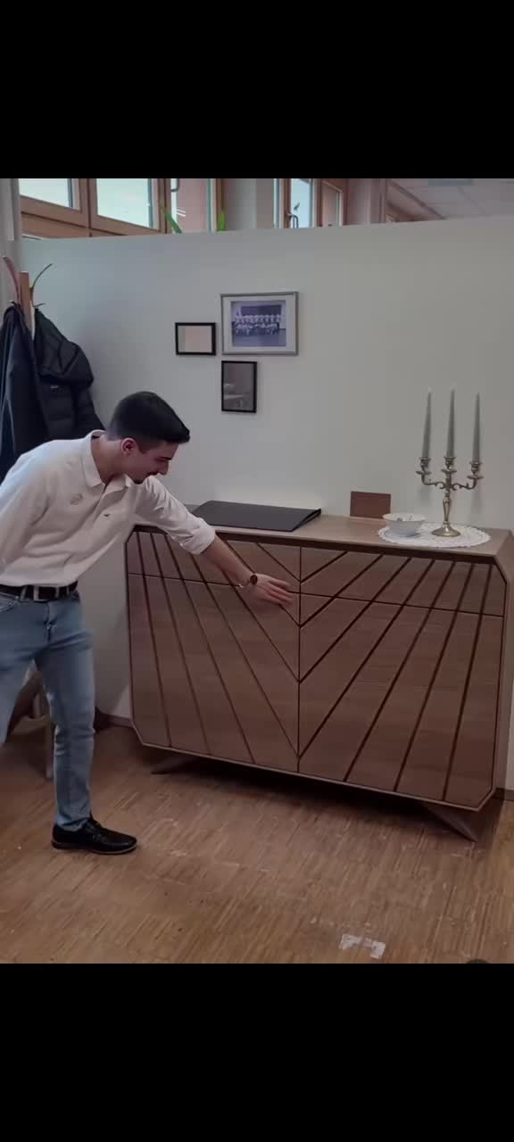 This may contain: a man standing in front of a wooden cabinet