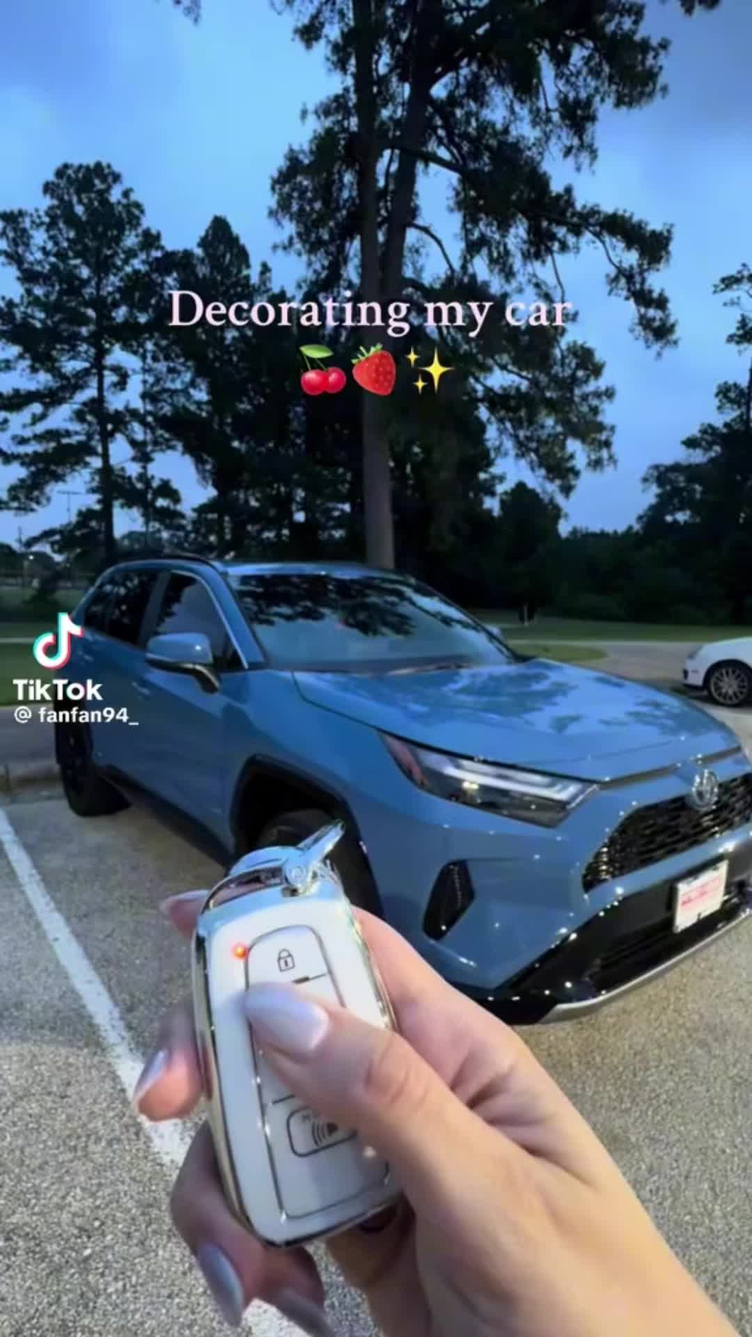 This may contain: a person holding a cell phone in front of a blue toyota car with the words decorating my car on it