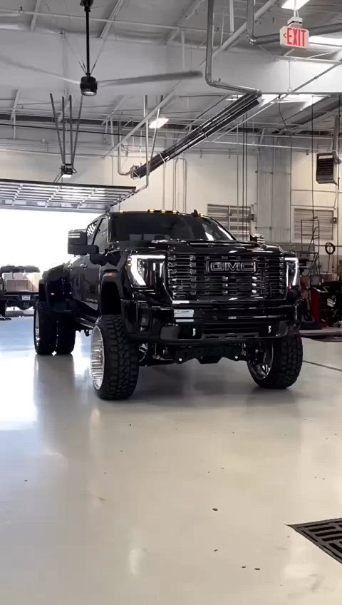 This may contain: a large black truck parked in a garage