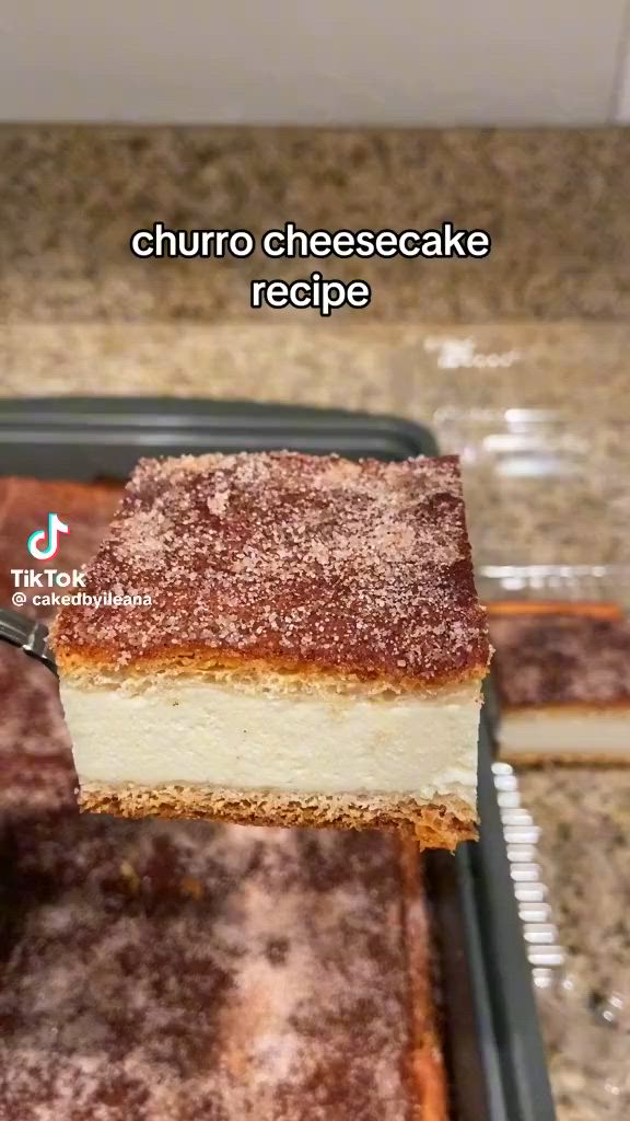 This may contain: a piece of cheesecake being lifted from a pan by a fork with the words churro cheesecake recipe on it