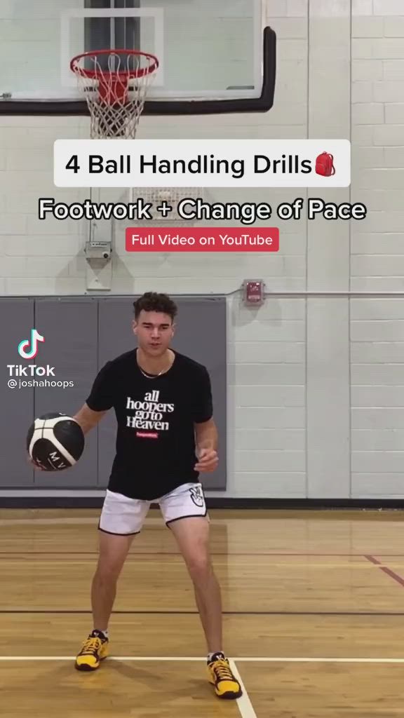 This may contain: a young man holding a basketball on top of a hard wood floor in a gym