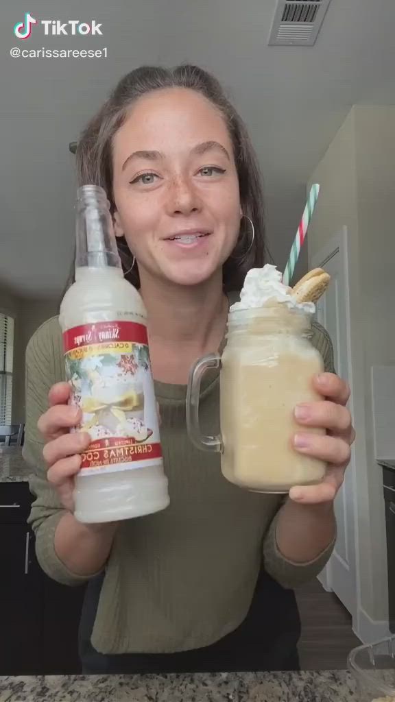 This may contain: a woman is holding a jar with whipped cream in it