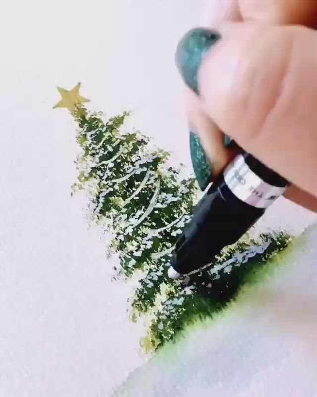 This may contain: someone is drawing a christmas tree on paper