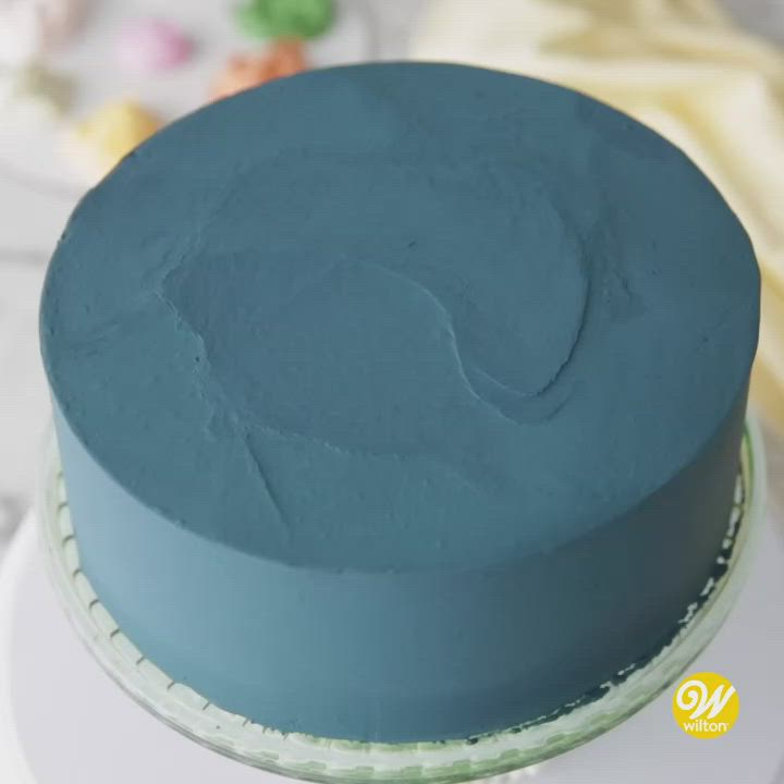 This may contain: a blue cake sitting on top of a white plate