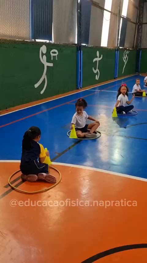 This may contain: children sitting on the floor playing with toys in an indoor gym area while adults watch