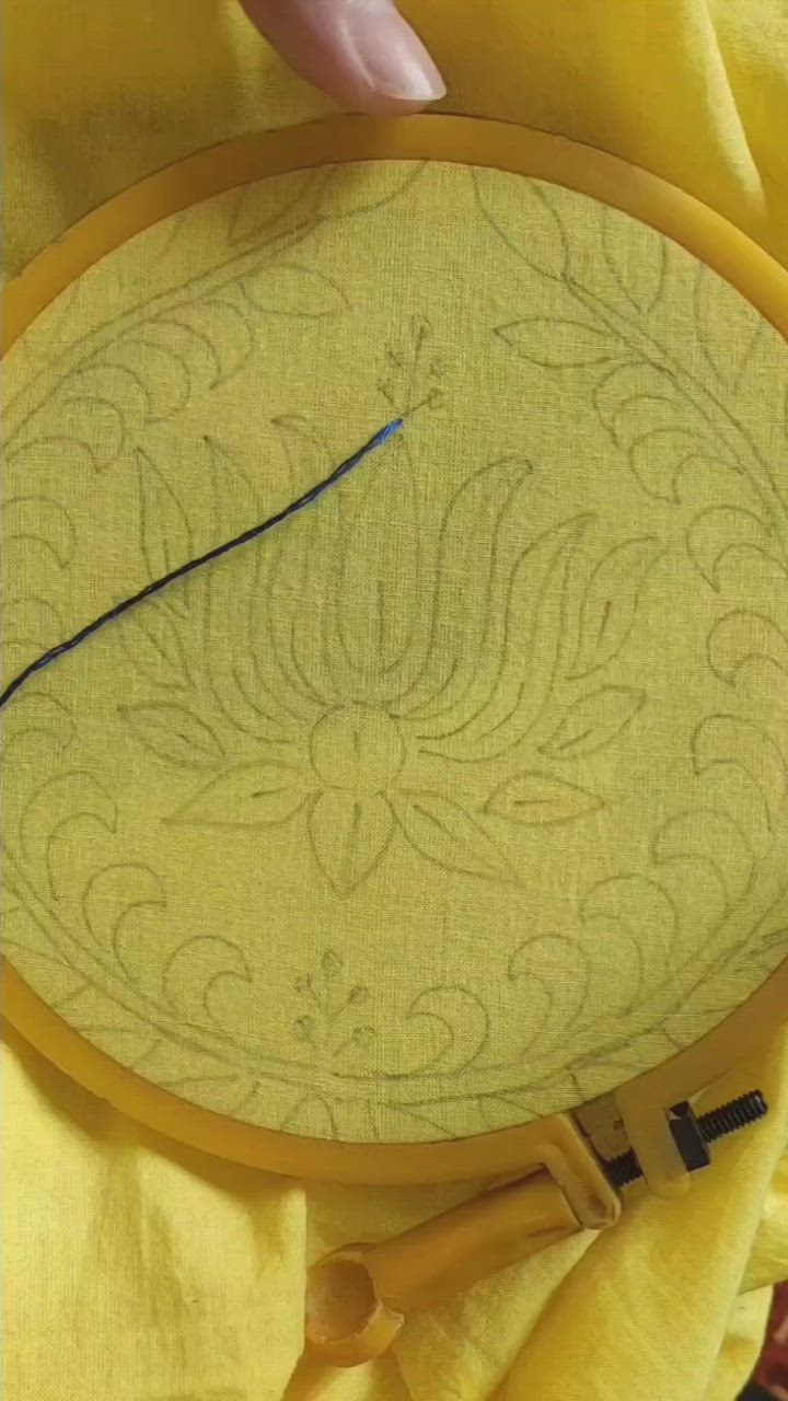 This may contain: someone is stitching on the back of a yellow piece of fabric