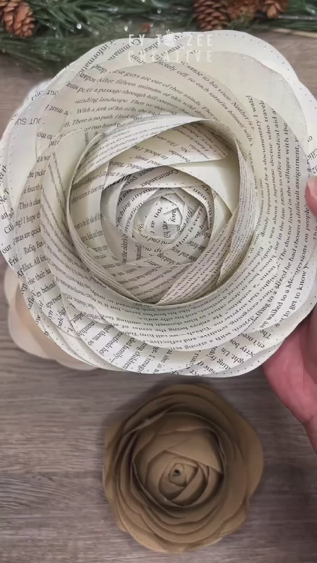 This may contain: someone is holding an origami flower made out of book pages