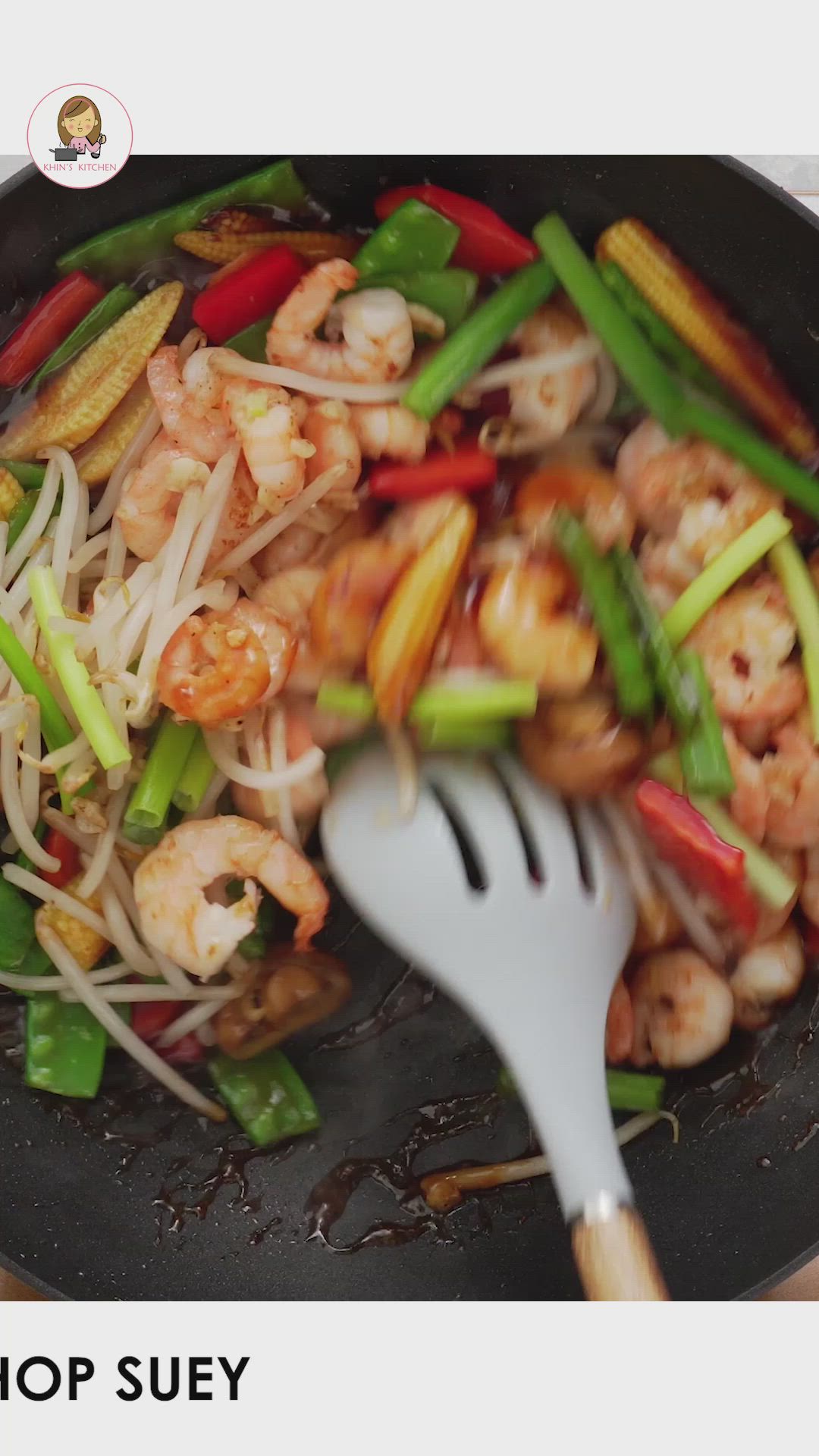 This may contain: a skillet filled with shrimp and vegetables on top of a wooden table next to the words prawn chop suey