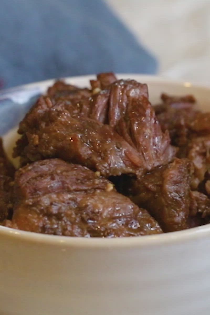 This may contain: a white bowl filled with meat and rice