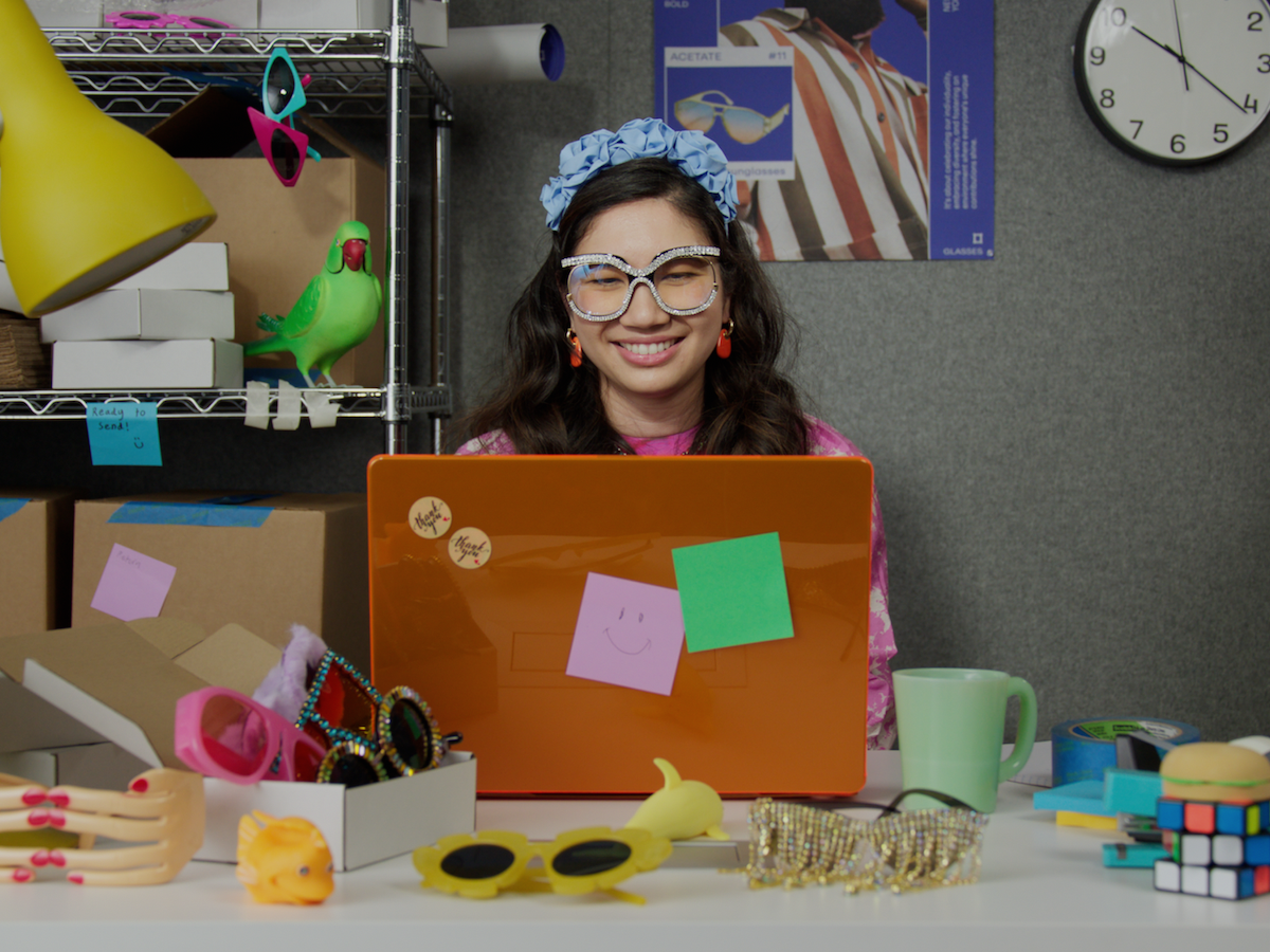 A woman reading a video transcript on her laptop and smiling