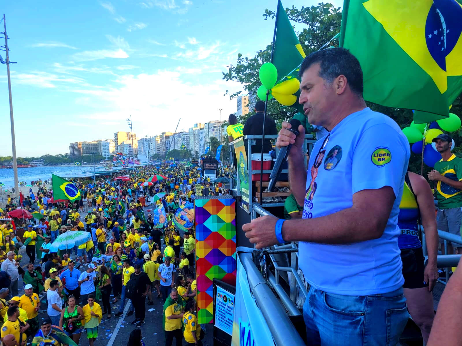 Pastor Liomar é um homem branco com cabelos e olhos escuros. Ele veste camisa branca e discursa do alto de um carro de som no Rio de Janeiro.