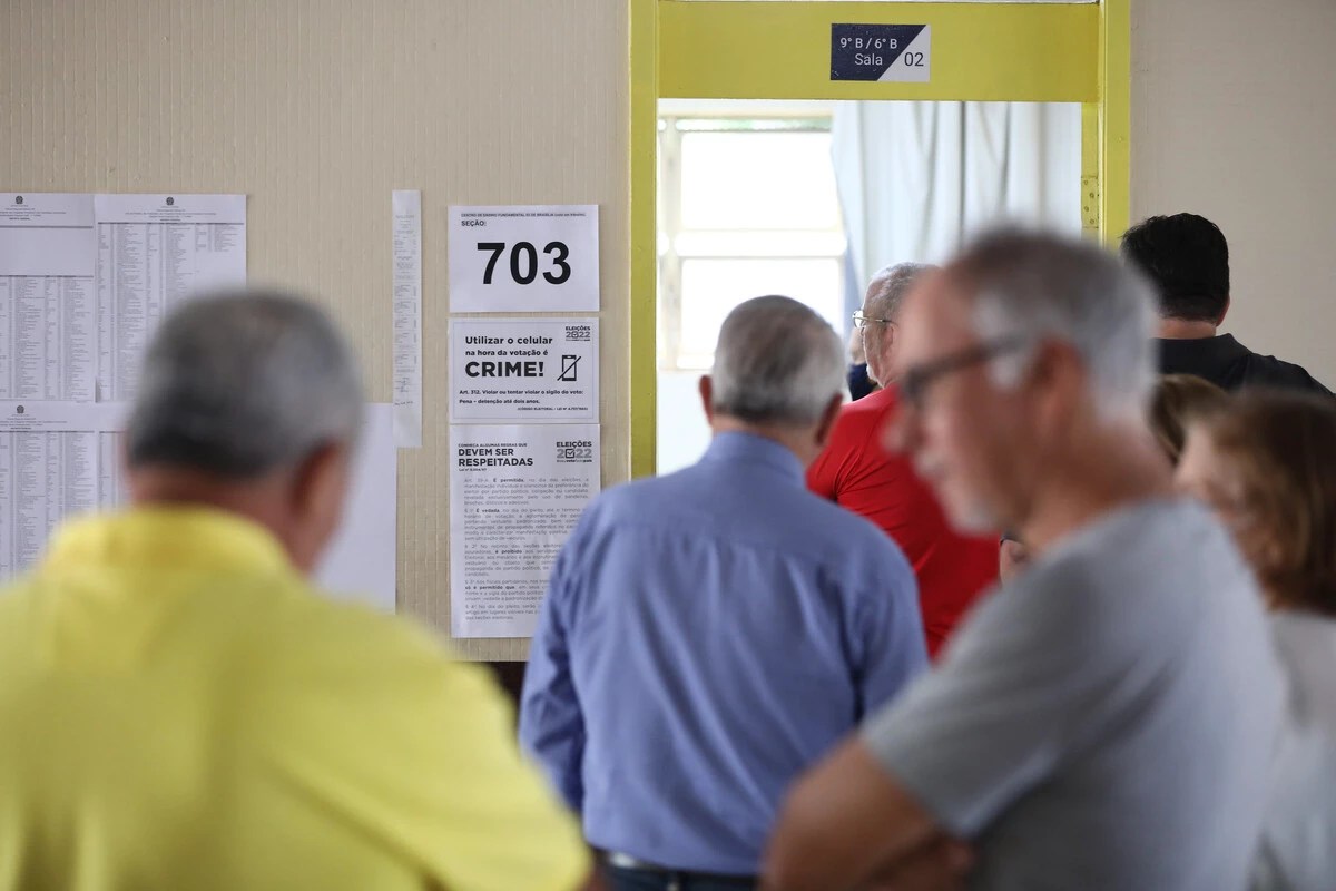 Fila de pessoas para votar em seção eleitoral.