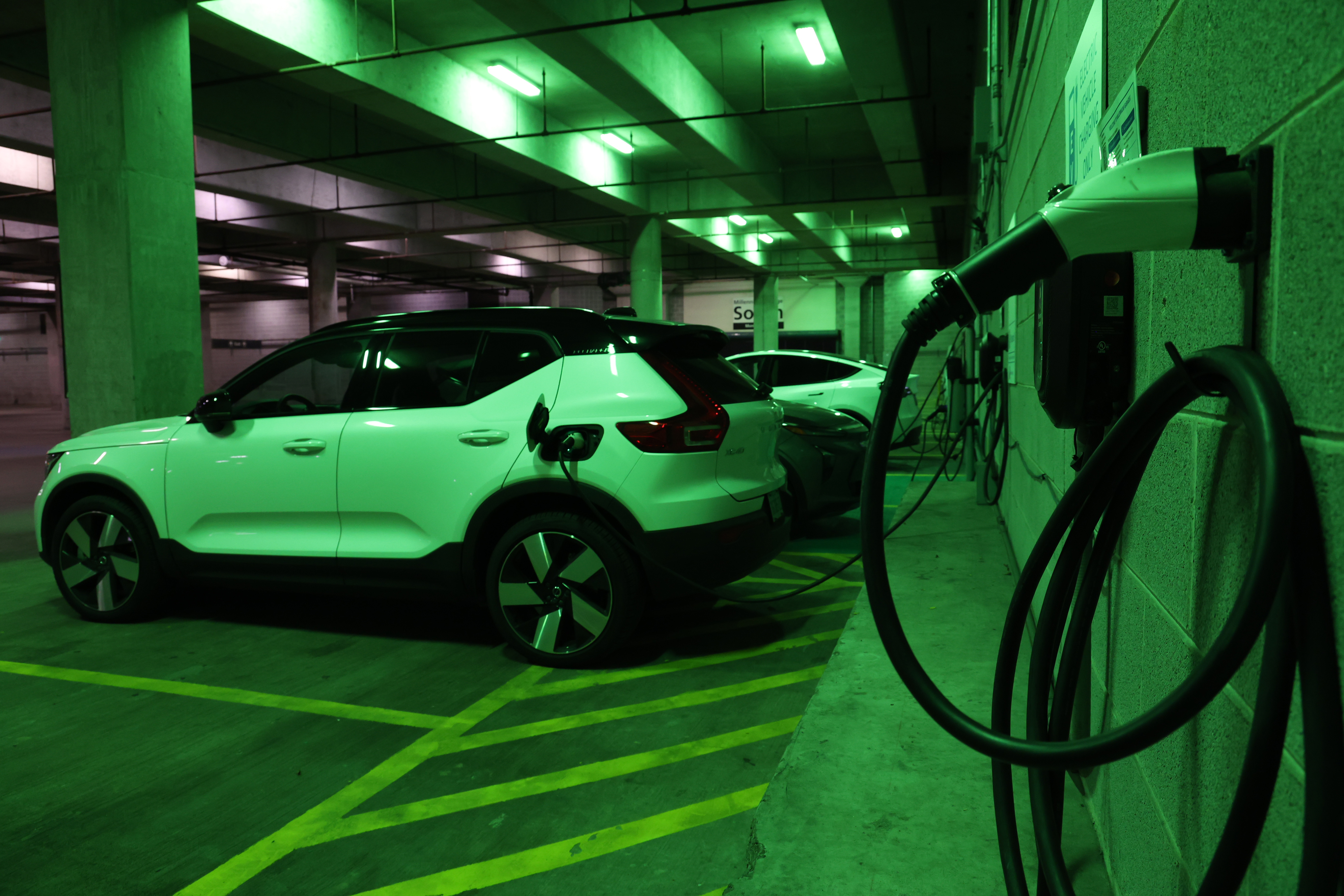 Three cars use the EV chargers inside of the Millennium Garages on Oct. 4, 2023, in Chicago. (Stacey Wescott/Chicago Tribune)